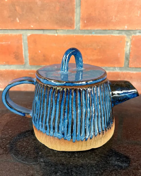 A beautiful hand-built teapot with carved vertical lines and a rich blue glaze. This piece was made by a student in my 15-day hand-building course.