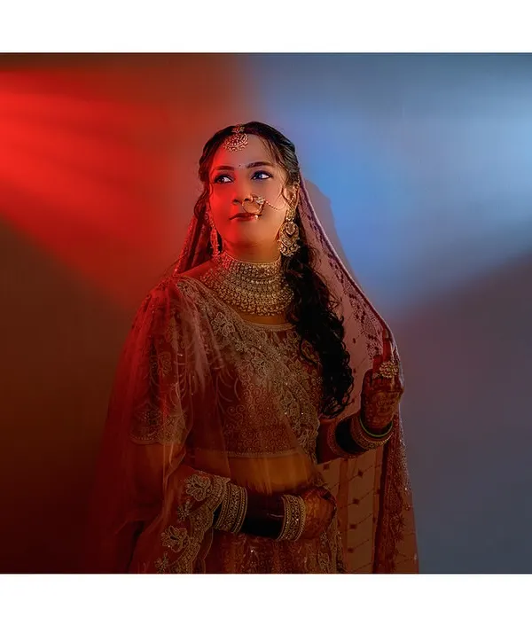 A creative bridal portrait using red and blue lights to create a dramatic and modern look. She stands as the perfect balance between passion and serenity.