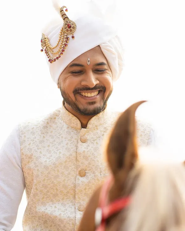 A groom's smile on his wedding day is priceless. Here, I provided grooming that looks completely natural in the bright daylight, along with styling for his traditional white Pheta.