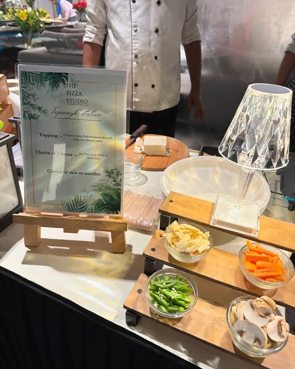 This is a close-up of our live Teppanyaki station. You can see the neatly arranged ingredients like sliced mushrooms, carrots, and beans, ready for our chef to grill them to perfection for your guests.