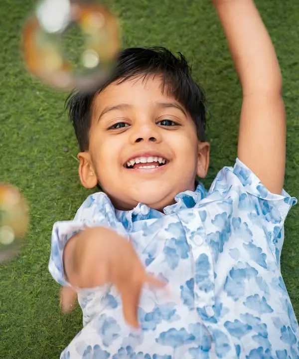 Pure happiness. Capturing a child's joy while playing with bubbles during an outdoor session on the grass.