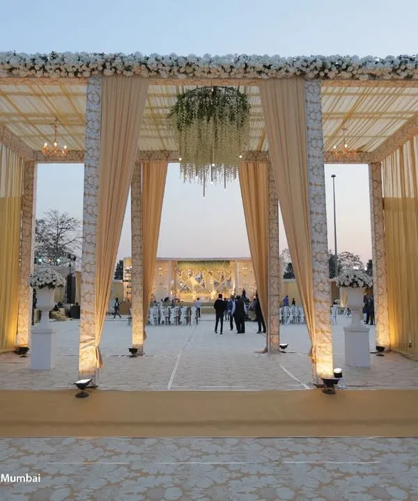 We build structures that impress. This main gate, constructed with a large truss, elegant drapery, and leather paneling, creates a grand and sophisticated entrance for a large-scale wedding.