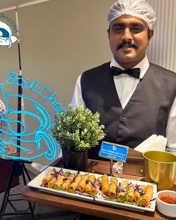 My staff, dressed in professional attire, ready to serve at an event. The glowing Soul Chef neon sign in the background is a symbol of the energy and passion we bring. This image shows our readiness to create a magical experience.