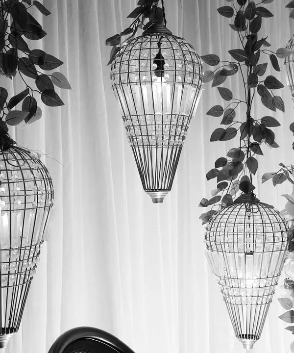 A black and white shot highlighting the beautiful form of our birdcage-style hanging lanterns. These details add a layer of sophistication and visual interest to our stage designs.