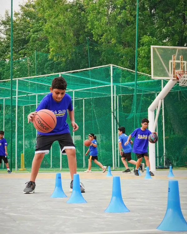 A young player practices dribbling around cones, a fundamental drill for improving ball control and agility. We teach kids to navigate tight spaces, which is a crucial skill for moving past defenders in a real game.