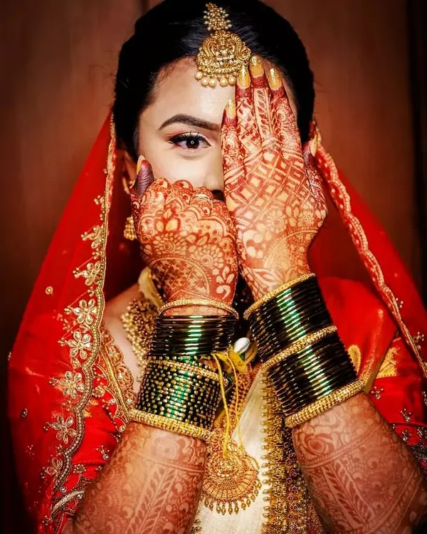 A bride's joy is the most beautiful thing to witness. I love this classic pose that showcases the intricate henna details against her stunning red and gold wedding attire. The fine lines and traditional patterns are designed to complement her entire bridal look.
