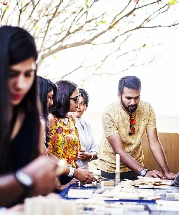 A facilitator guides a team at an outdoor event. We adapt our sessions to fit any environment, providing all the necessary equipment to create an engaging and productive team-building experience for your group.