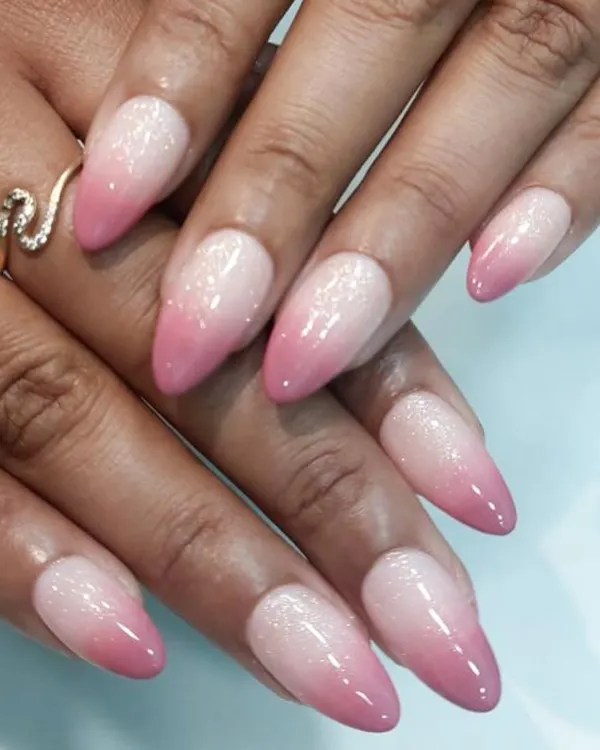 A classic pink and white ombre on elegant, pointed almond nails. The seamless blend and subtle glitter finish create a look of pure sophistication.