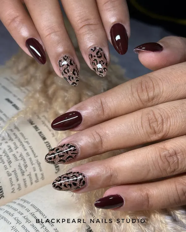A design that is both wild and elegant, featuring deep brown nails paired with a fierce cheetah print with a glittery glow. This is a show-stopping look for those who want to make a bold statement.