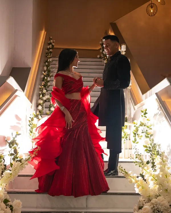 For this couple's reception in Australia, we went for a timeless red and black theme. I styled the bride in a dramatic, sculptural Gaurav Gupta gown and the groom in a dapper Shantanu Nikhil ensemble to create a look that was both classic and unforgettable.