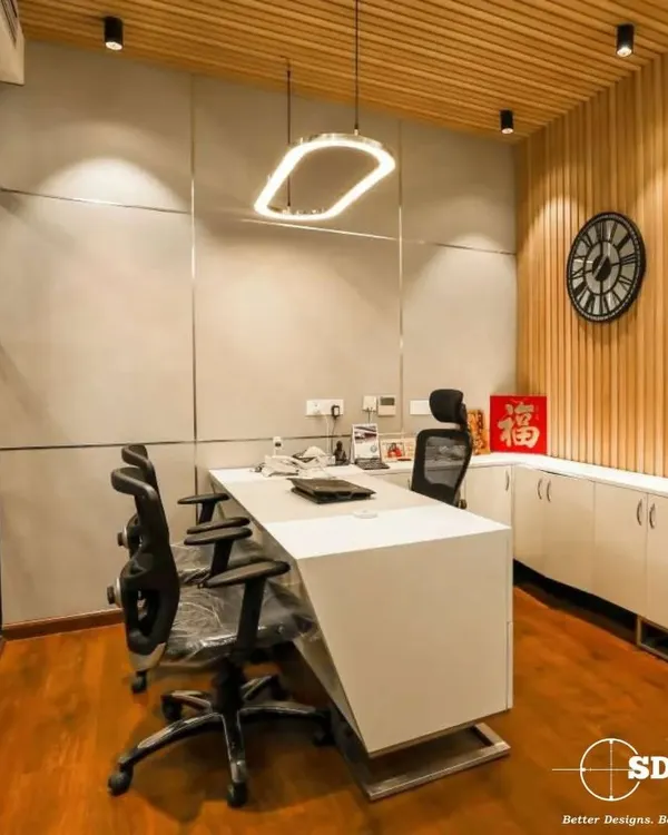 A view of a modern executive cabin we designed, featuring clean lines, wood-paneled accent walls, and contemporary lighting. This space is built for focus and decision making, reflecting a balance of authority and sophisticated style.