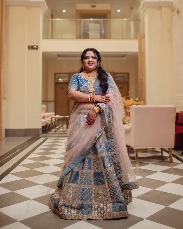 A full-length view of this bride's stunning reception look. Her blue and silver lehenga was complemented by a dramatic smokey eye and a soft pink lip.
