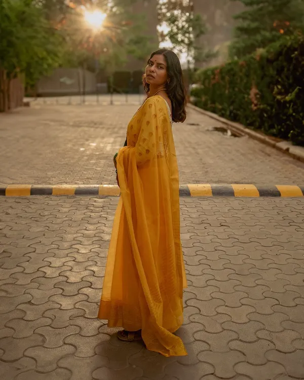 A stunning golden hour portrait of a woman in a vibrant yellow saree, captured on a paved path. This shot showcases my love for using natural light to create atmospheric and elegant outdoor portraits.