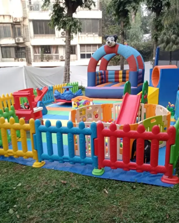I transform your outdoor space into a vibrant and safe play paradise. This setup in a client's garden features a bouncy castle with a slide, a separate tunnel climber, and colorful safety fencing, all on top of soft foam flooring so kids can play freely and parents can relax.