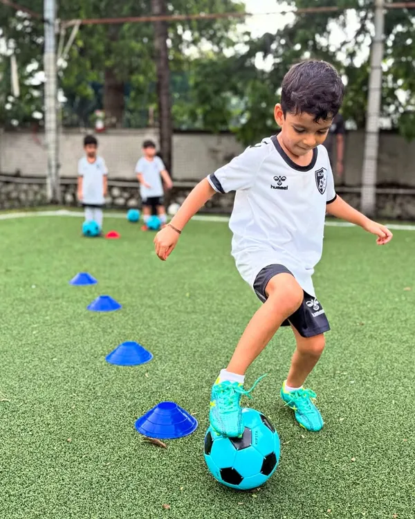 A young player navigates a cone drill, a fundamental exercise we use to develop precise dribbling and close ball control from an early age.