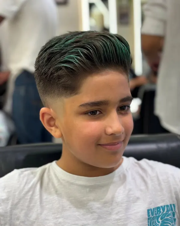 A close-up of a boy's fade haircut with a pop of vibrant green on top. This is a fun and stylish way to experiment with color and stand out from the crowd.
