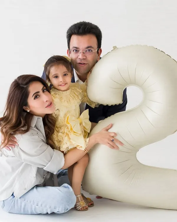 A classic family portrait for a second birthday celebration. The number '2' balloon adds a festive touch to this memory.