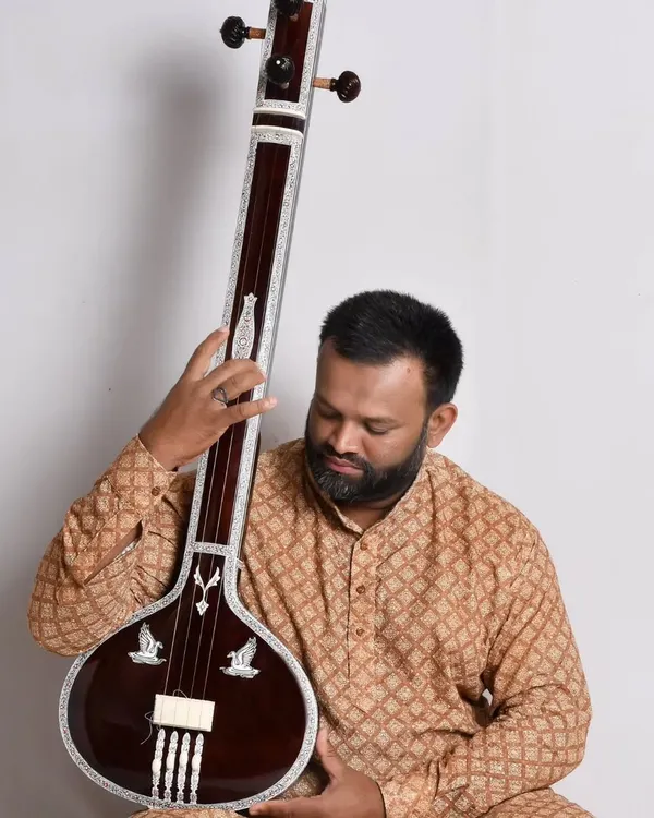 This is a flat wooden tanpuri I made, perfect for vocalists and for studio recordings. I am holding it here to show its size and simple, elegant design.