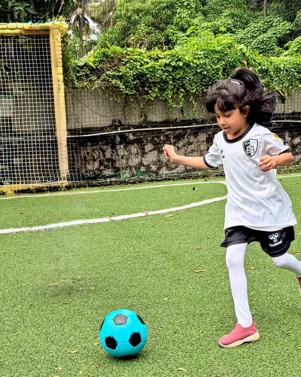 A young girl confidently dribbles the ball towards the goal, embodying the spirit and skill we nurture in our girls' football program.