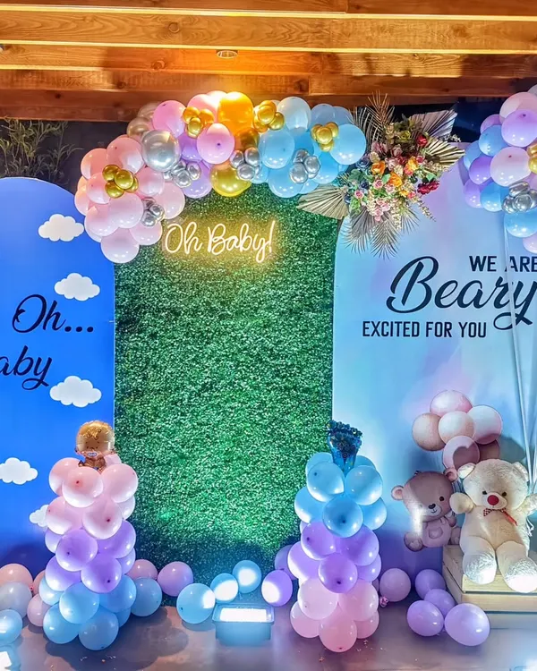 A beautiful 'Oh Baby' shower setup with a 'Beary Excited' theme. I used arched backdrops, a green hedge wall, a neon sign, and pastel balloon arrangements to create this modern and sweet look.
