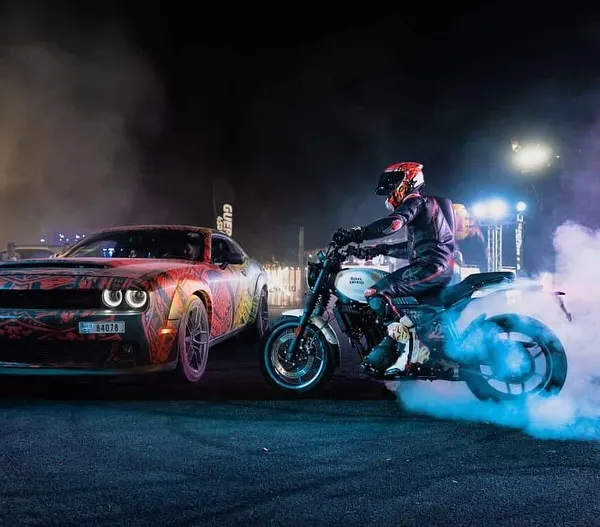 We bring the full cinematic experience to your event. Here, one of our riders performs a precision burnout alongside a custom Dodge Challenger, enveloped in dramatic smoke and lighting for an unforgettable night show.