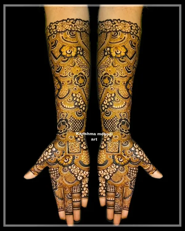 A highly intricate and dense bridal design with a focus on repeating geometric and floral motifs. The use of negative space with dark henna creates a stunning contrast, showcasing exceptional skill and precision.
