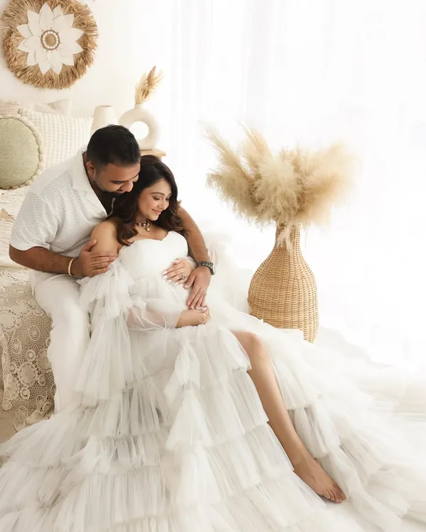 A dreamy and ethereal maternity portrait. The flowing white tulle gown and soft lighting in my boho studio setup create a truly magical and timeless image for this mama-to-be.