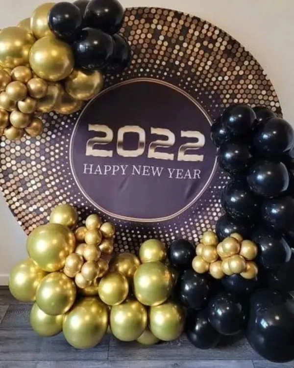 I designed this glamorous New Year's Eve photo booth to be the centerpiece of the party. It features a large circular backdrop with a sparkling sequin finish, bold "2022 Happy New Year" text, and an organic arrangement of chrome gold and matte black balloons to create a sophisticated look.