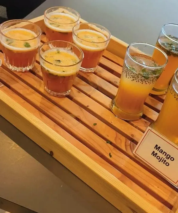 A tray of our refreshing welcome drinks, featuring Mango Mojito and Fruit Punch. These mocktails are a perfect start to any corporate meet or party, especially during the summer.