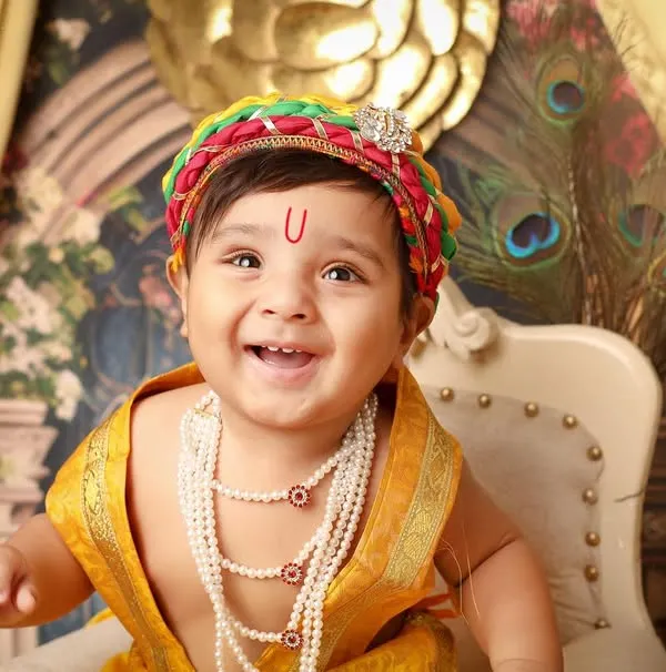 The joyful and mischievous smile of little Krishna is perfectly captured in this close-up. The colorful mukut and pearl necklaces are part of the traditional costume I provide for my Janmashtami themed photoshoots.