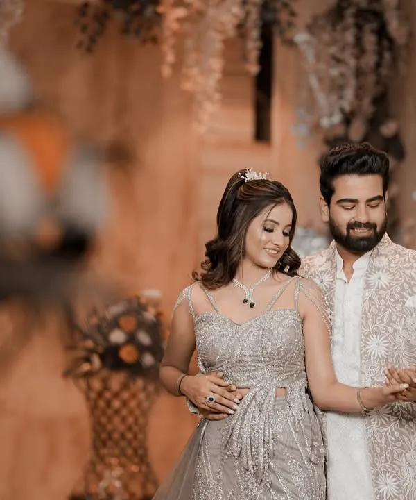 The couple shares a dance during their engagement celebration, dressed in elegant, coordinated outfits. This shot captures the romantic atmosphere of the event, with soft lighting and beautiful decor in the background.