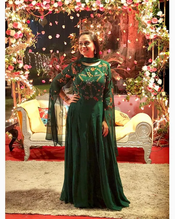 An emerald green Anarkali gown makes a sophisticated statement at any wedding function. The playful bell sleeves are a current trend, while the intricate embroidery on the bodice adds a touch of timeless grace.