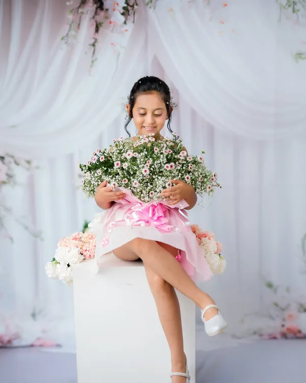 A beautiful portrait of an older child in a dreamy, floral studio setup. She looks like a little princess.