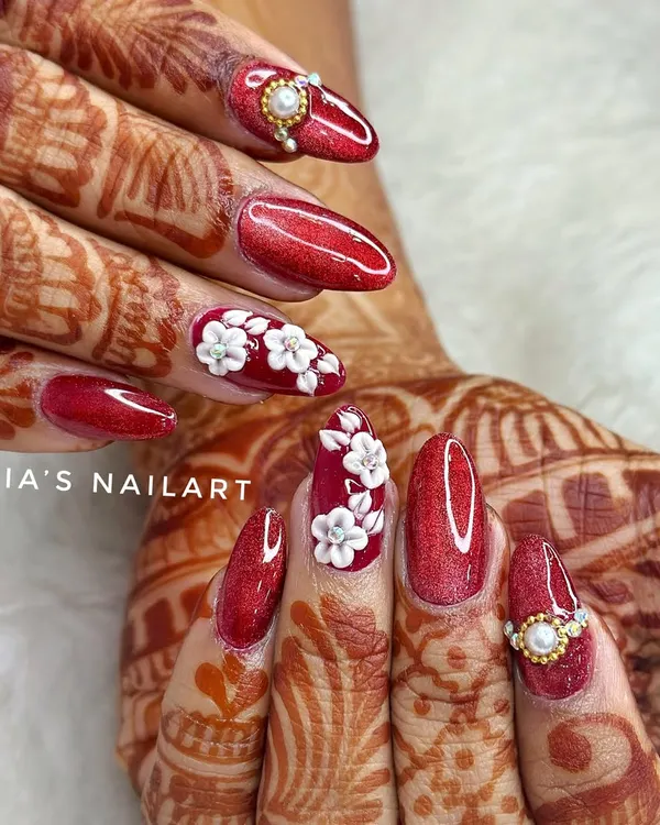 A classic bridal look for a reason. This set features a rich, glittery red base with hand-sculpted 3D white acrylic flowers and elegant pearl and diamond accents. Perfect for the traditional bride.