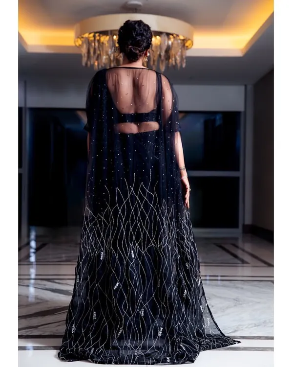 The back of this stunning black gown I designed for Anupama Gowda. It features a sheer cape with delicate silver embroidery, creating a dramatic and elegant silhouette that is perfect for a grand entrance.
