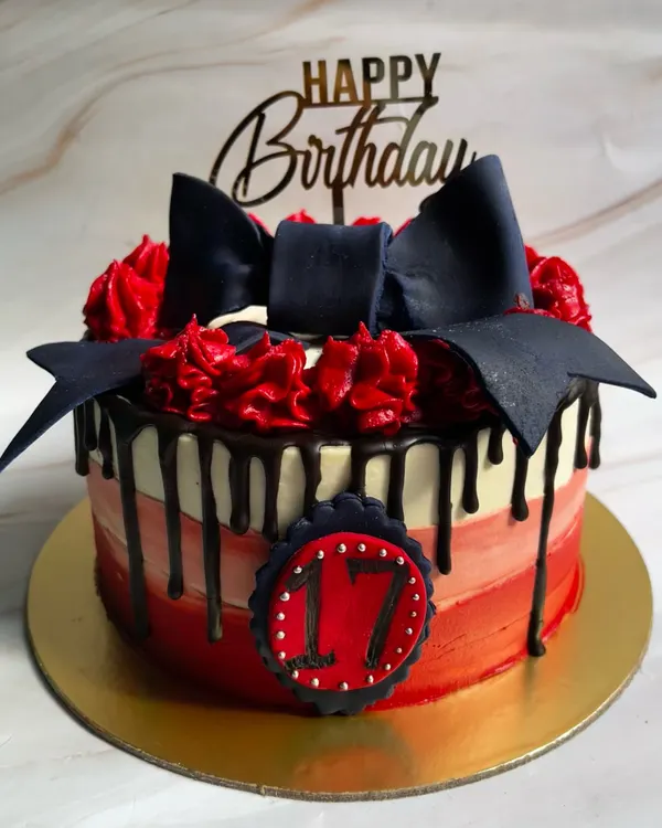 Can I call you rose? Our Classic Chocolate Truffle Cake gets a dramatic makeover with a red ombre finish, chocolate drip, and a striking black fondant bow for a 17th birthday.