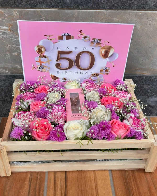 A stunning floral crate designed for a fabulous 50th birthday. This arrangement combines fresh, vibrant flowers with a personalized touch, making it the perfect centerpiece for a milestone celebration.