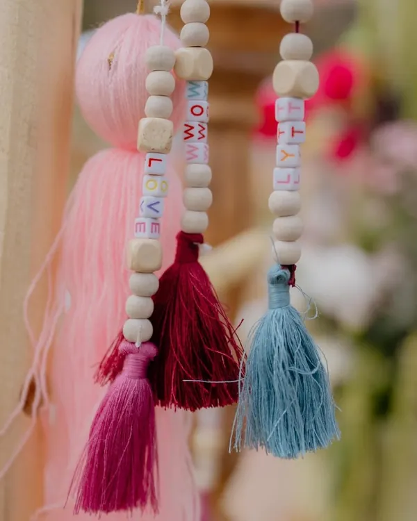 It's the little things. For this event, we created custom tassels with lettered beads spelling out words like 'LOVE' and 'RHYTHM', adding a playful and personal touch.