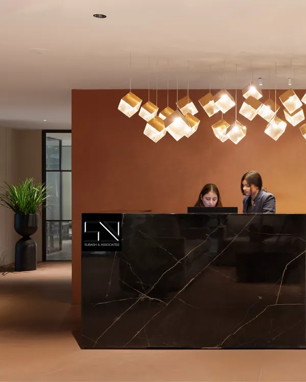 The reception at Jubilee Walk Headquarters, designed to be the first point of contact with the brand's ethos. The solid black marble desk, complemented by a cascade of geometric pendant lights, establishes an immediate sense of modern luxury and professionalism.