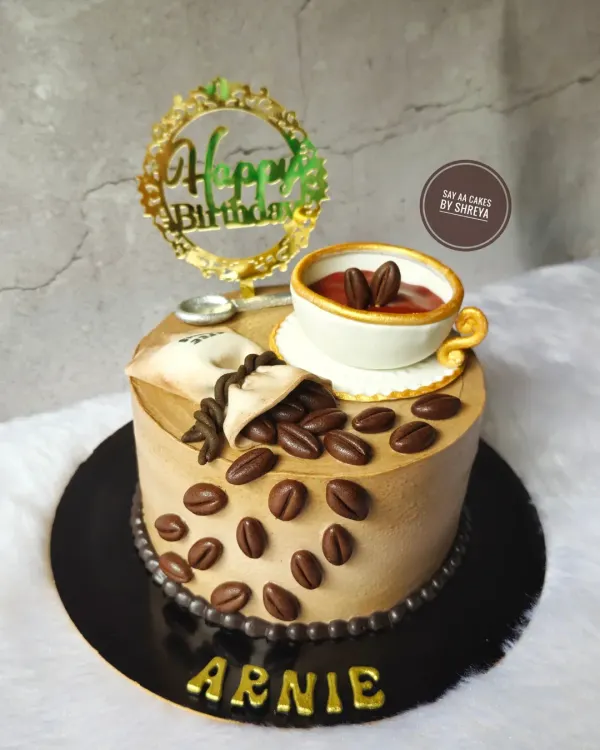 For those who love their cake like their coffee: rich and strong. This design features an edible, handcrafted coffee cup, spilling over with fondant coffee beans, making it the perfect birthday cake for a caffeine aficionado.