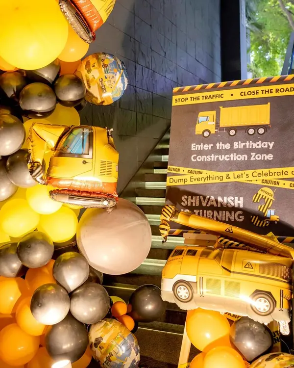 Welcome to the construction zone. I set the scene right from the entrance with a custom sign, truck-shaped mylar balloons, and a yellow and black balloon garland to get the little builders excited for the party.