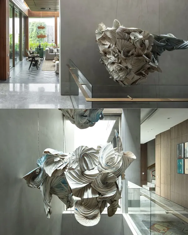 A diptych showing two views of a cascading origami-inspired light installation made from parchment. Suspended in a triple-height atrium, it introduces softness and a sense of weightless movement into an architectural void.