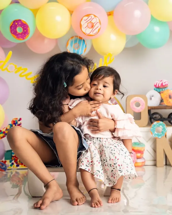 A sweet moment between two sisters during a donut-themed first birthday shoot. We love capturing the natural affection between siblings, from gentle kisses to playful giggles.