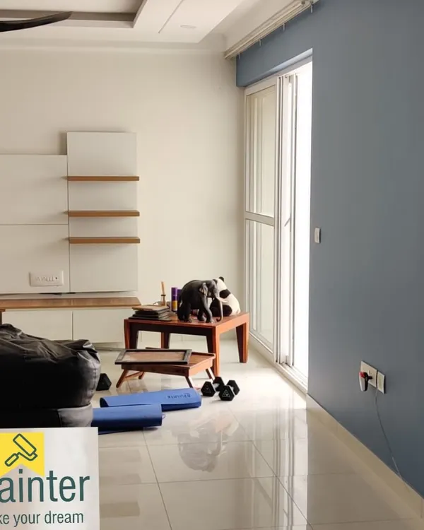 A modern living room with a sophisticated grey-blue accent wall contrasting with clean white walls. This two-tone approach adds depth and style.