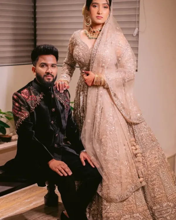 In this portrait, the groom's structured black velvet sherwani with its detailed embroidery provides a beautiful contrast to the bride's shimmering champagne lehenga. I designed his outfit to be strong and regal, yet complementary.