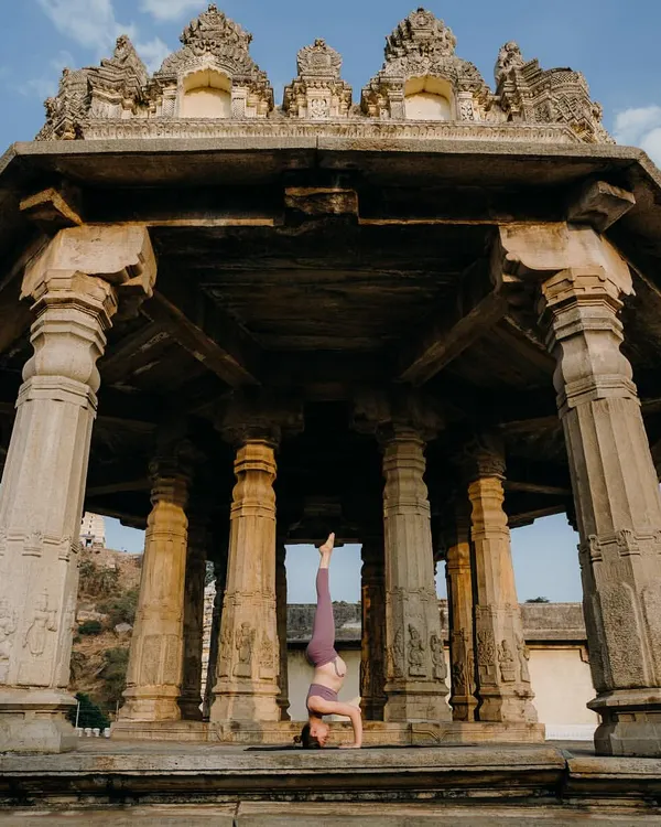 Practicing Pincha Mayurasana (Forearm Stand) inside a historic Indian temple. The stability and focus required for inversions feel amplified in such a powerful, ancient space.