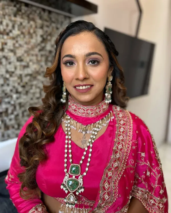 A perfect example of soft glam for a wedding guest. This look features a warm, shimmery eyeshadow, glowing skin, and a complementary lip color, all designed to enhance her features and match her vibrant pink outfit.
