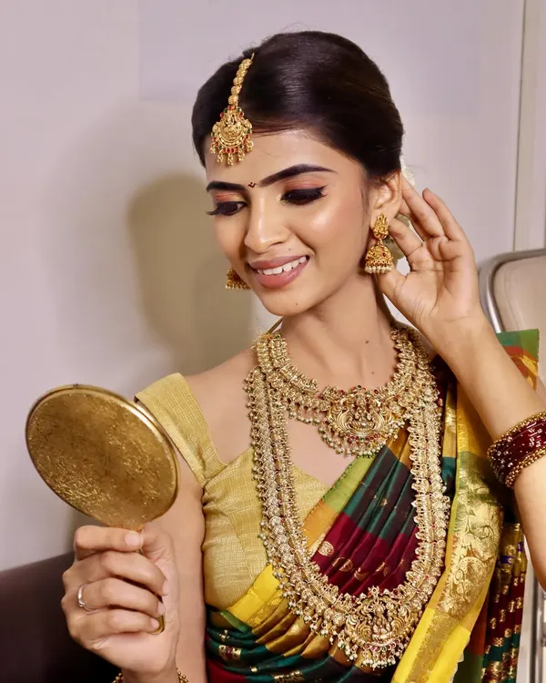 This stunning South Indian bridal look, created by our students, showcases the intricate details we teach, from the perfect winged eyeliner to the traditional jewelry placement.