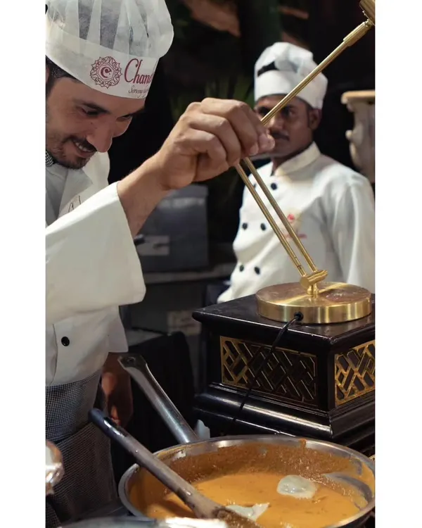A smiling chef at our live Palak Paneer Ravioli station. The joy he takes in his craft is evident as he prepares this unique fusion dish.