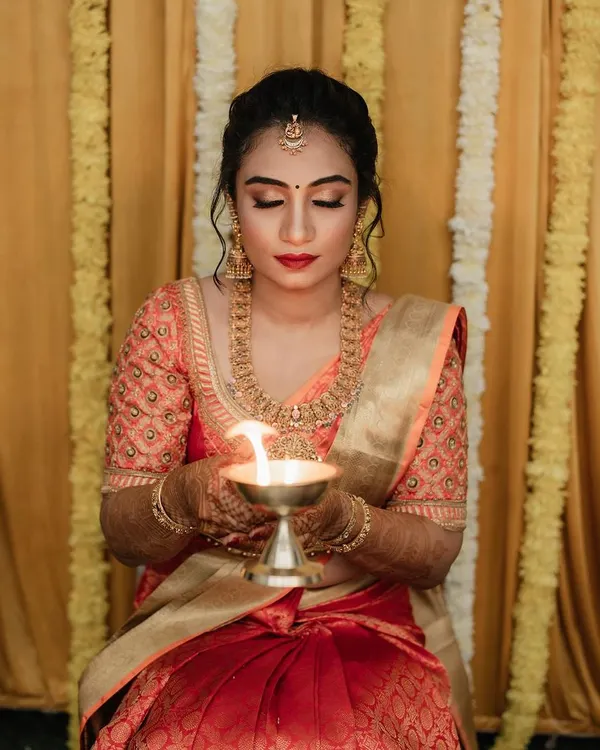 This is the look I absolutely love creating. For her bangle ceremony, we went with a classic South Indian style, focusing on flawless skin, bold red lips, and eyes that tell a story. It's all about capturing that serene, traditional glow.